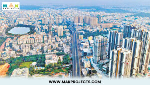 Arial View Of Hyderabad'S Modern Skyline With High-Rise Buildings, Well-Planned Infrastructure, And Residential Areas, Showcasing Urban Development. Mak Projects Logo In The Top Left Corner And Website Link Www.makprojects.com At The Bottom